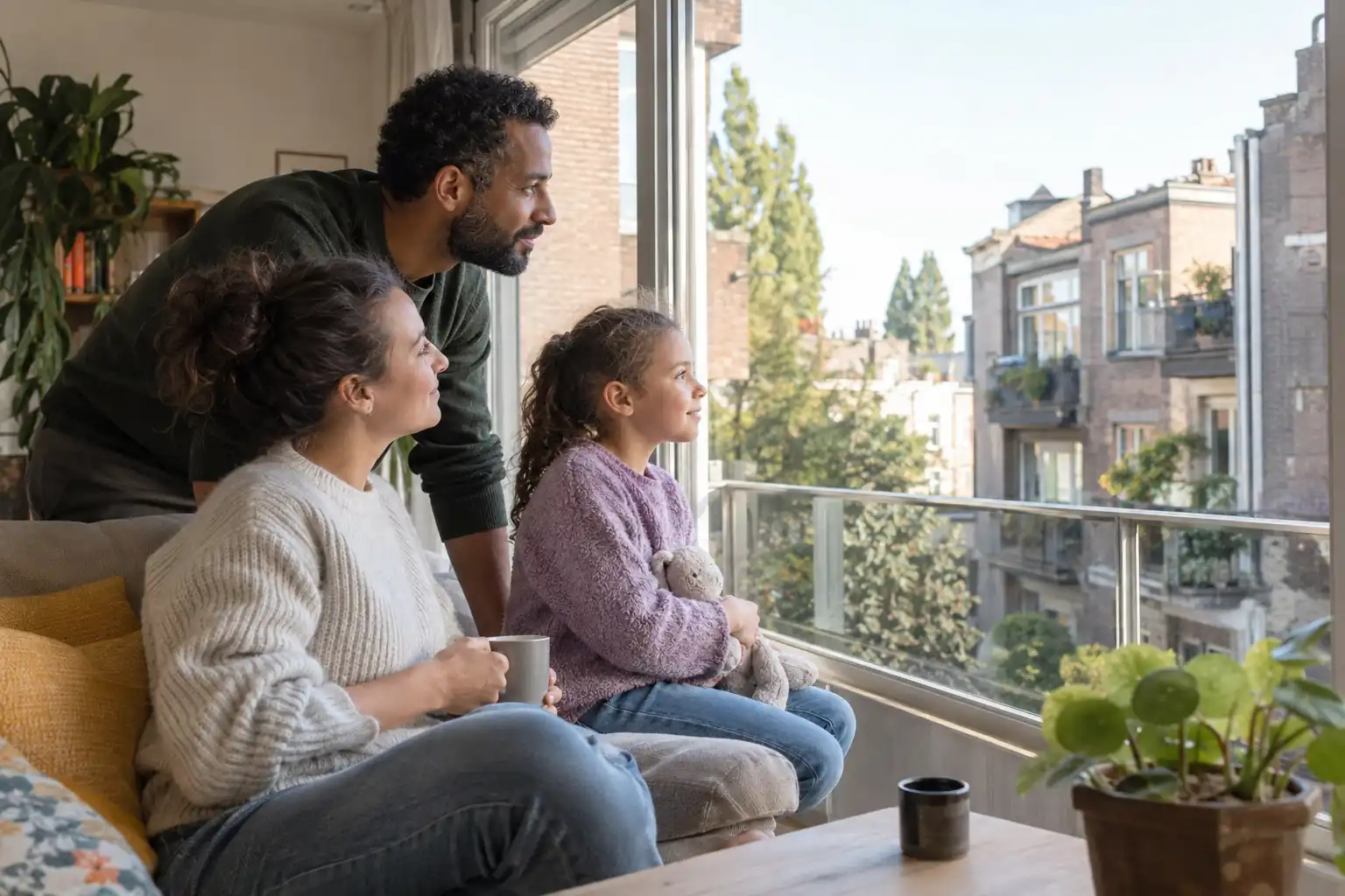 Une famille regarde son quartier depuis la fenêtre de son logement